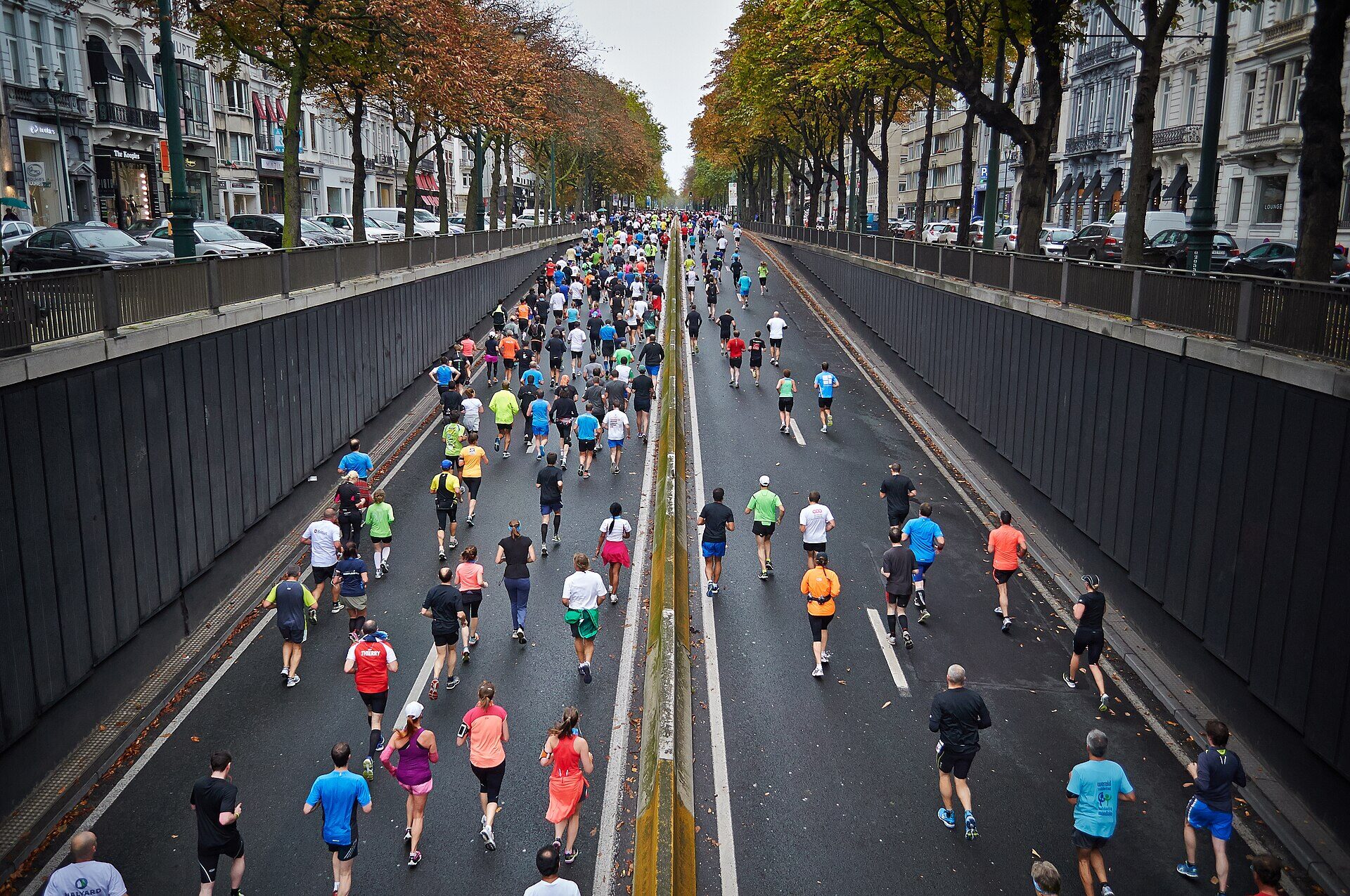 Corredores avanzando en grupo por una avenida durante una carrera