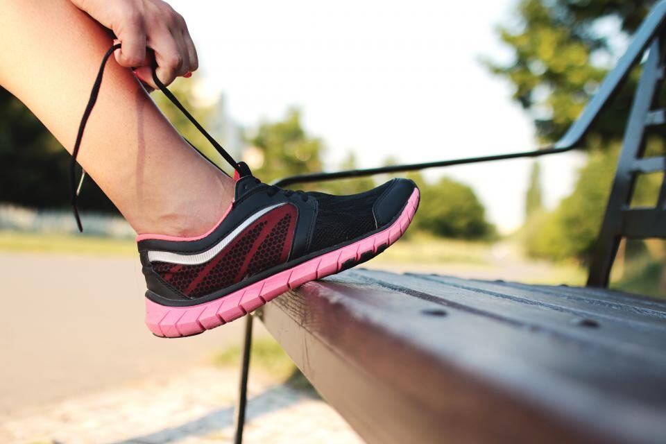 Persona atándose las agujetas de un tenis para correr